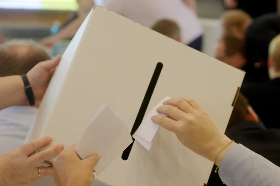 Stimmzettel werden bei der Abstimmung in eine