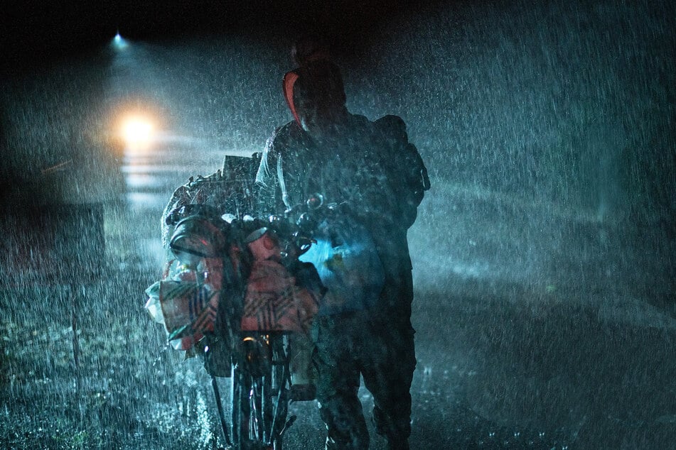 In der regnerischen Nacht kämpft "Foxy" sich mit seinem Fahrrad die Solitude hinauf, als sich ein Wagen von hinten nähert.