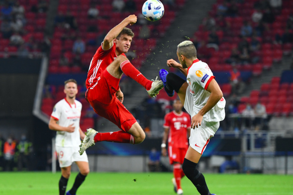 Sevillas Luuk de Jong (r.) und Bayerns Thomas Müller kämpfen um den Ball.