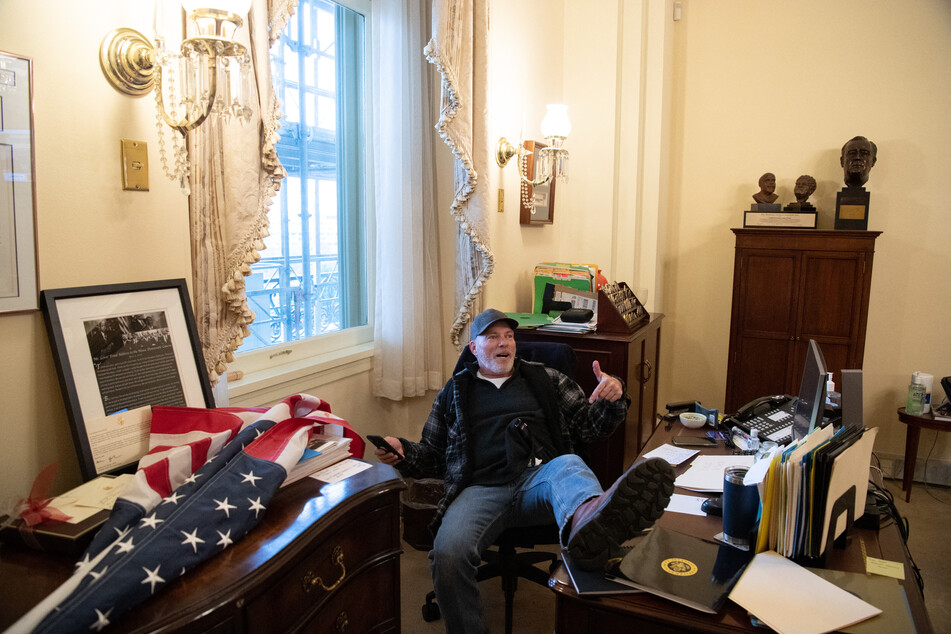 Richard Barnett puts his feet on former House Speaker Nancy Pelosi's desk during the January 6, 2021, Capitol riot.