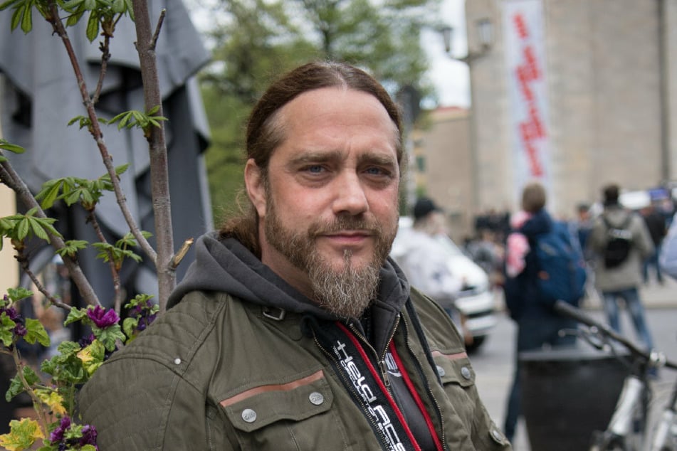 Der Musiker Martin Kesici beobachtet als Anwohner eine Kundgebung gegen die Corona-Einschränkungen.