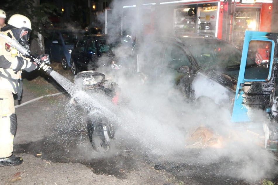 Einsatzkräfte der Feuerwehr löschen ein Motorrad, das von dem mutmaßlichen Brandstifter angezündet wurde.