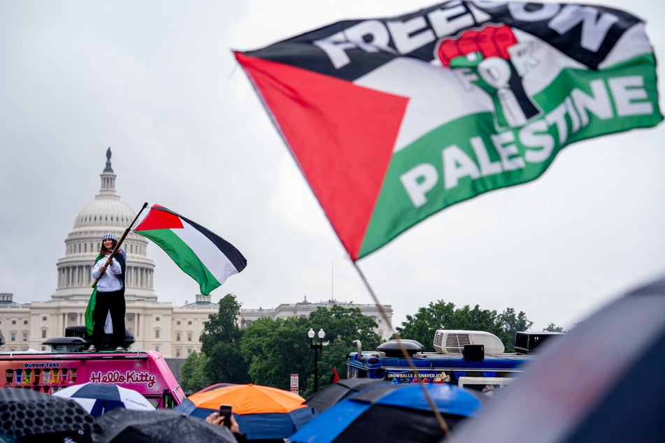 Protesters wave Palestinian flags during a "Nakba 76" rally on the National Mall in Washington DC on May 18, 2024.