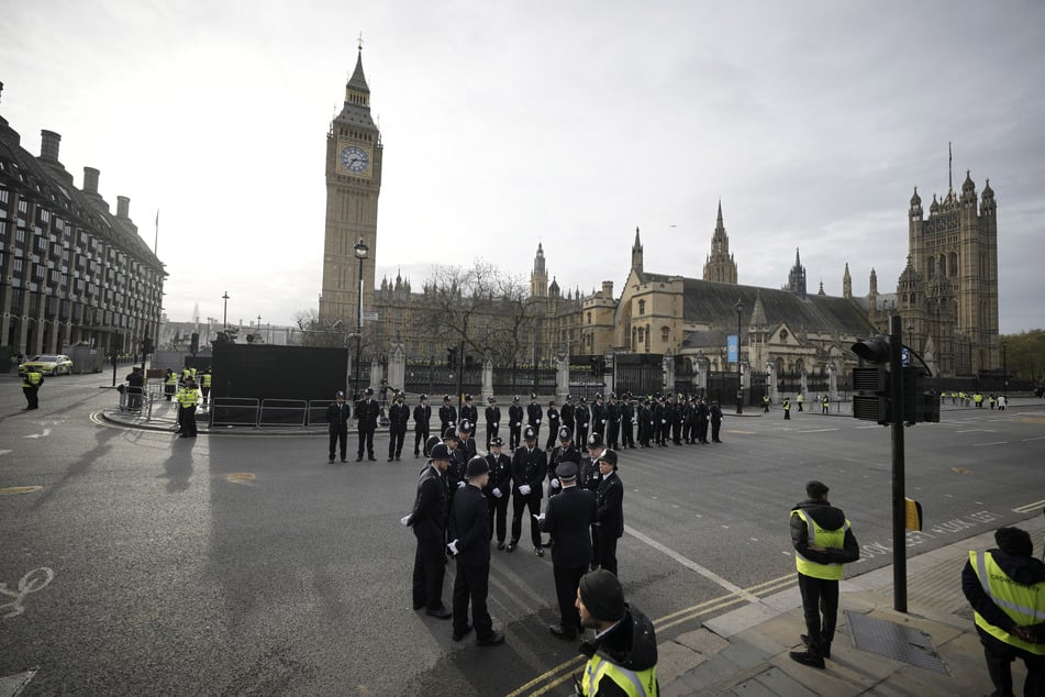 Polizisten stehen vor dem Palace of Westminster vor der Krönungszeremonie des britischen Königs Charles III. auf der Straße. Zur Krönung von König Charles III. werden Hunderttausende Menschen auf den Straßen Londons erwartet.