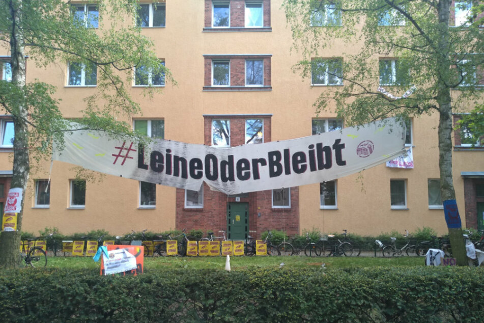 Ein Transparent mit dem Hashtag #LeineOderBleibt hängt vor der Leinestraße 36.