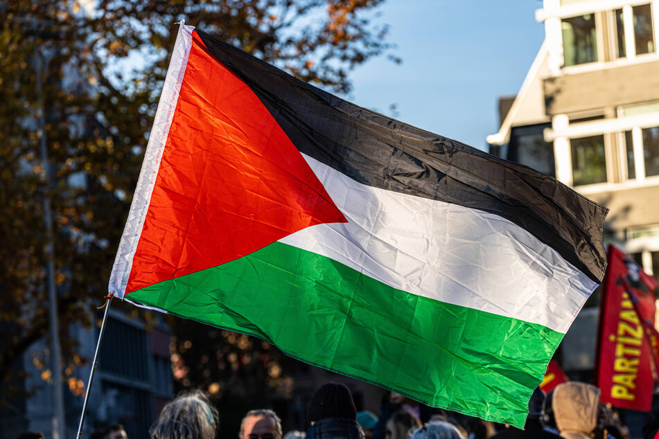 Demonstrators raise a Palestinian flag in solidarity with the besieged people of Gaza during a protest in Zürich, Switzerland.