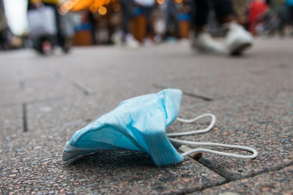 Eine Maske liegt in der Innenstadt auf dem Boden.