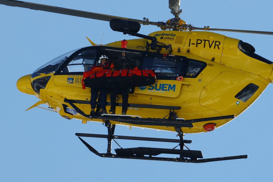 A helicopter carries Lindsey Vonn after she crashed during the women's downhill alpine skiing competition at the Milano-Cortina Olympics.