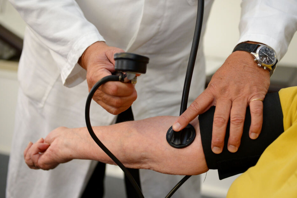 Ein Arzt misst bei einer Patientin den Blutdruck.