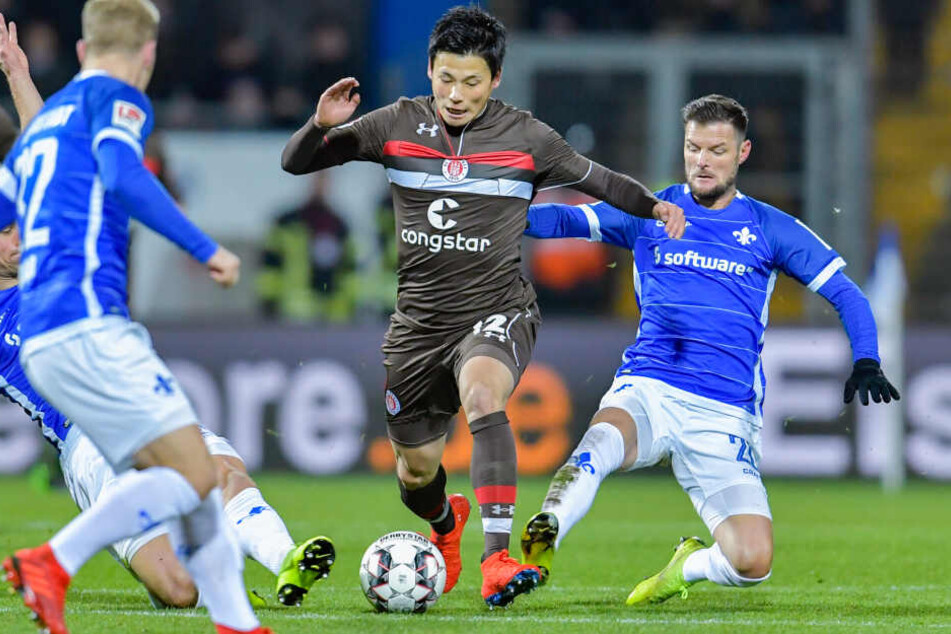 St. Paulis Ryo Miyaichi (links) und Darmstadts Marcel Heller im Zweikampf um den Ball.
