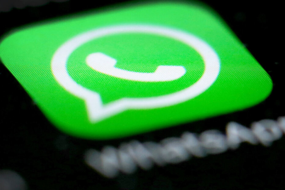 Das Logo der Messenger-App WhatsApp ist auf dem Display eines Smartphones zu sehen.
