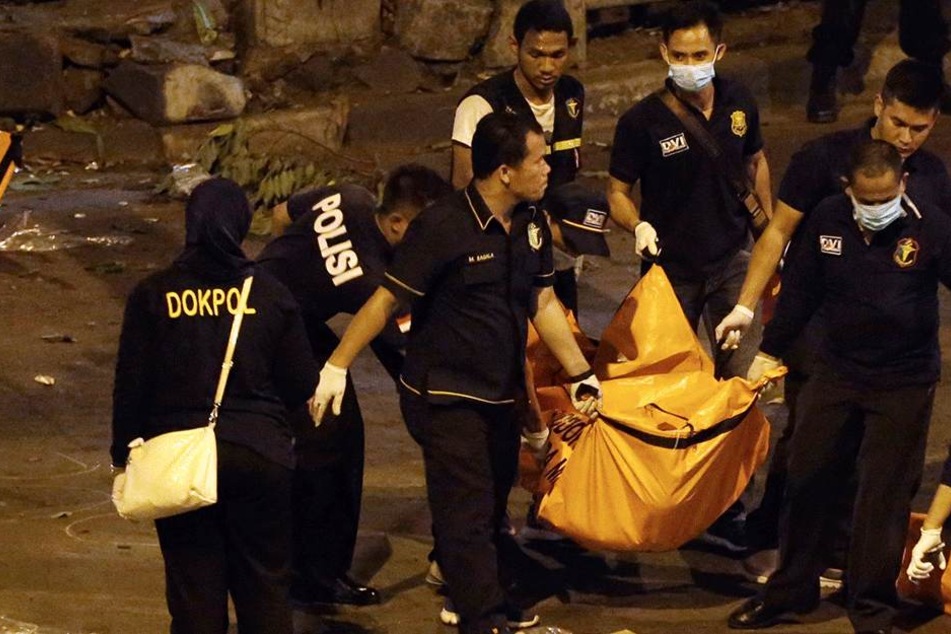 Polizisten tragen in Jakarta (Indonesien) einen Leichensack von einem Tatort weg (Archivbild).