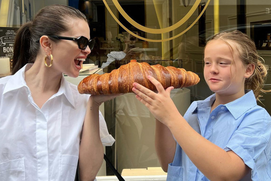 Selena Gomez (l.) and her sister Gracie share a large croissant while in Paris.