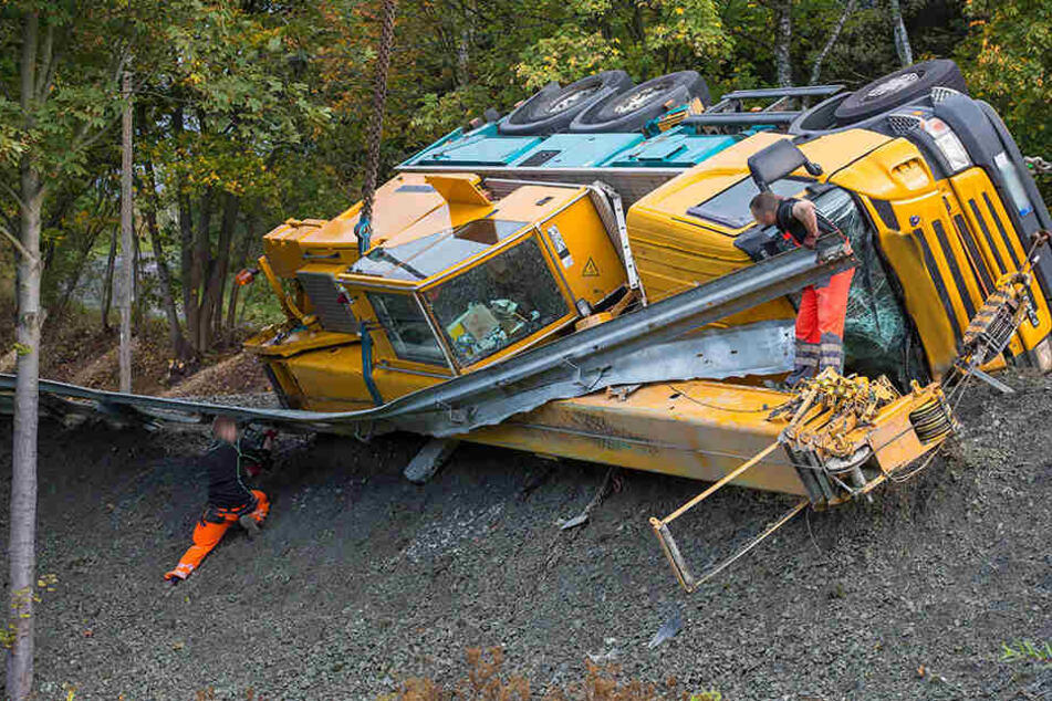 Der Kranwagen hat die Leitplanke durchbrochen und droht einen Abhang hinabzustürzen.