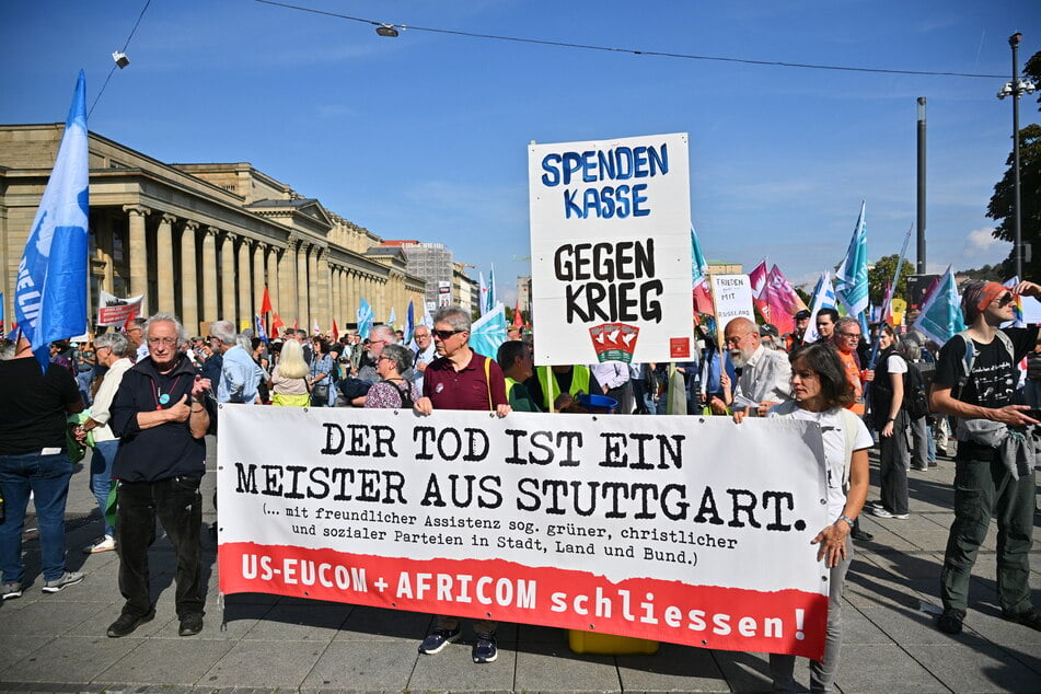 Teilnehmer hielten Banner mit der Aufschrift "Der Tod ist ein Meister aus Stuttgart." und "Nein zu Hochrüstung, Wehrpflicht und Krieg!" auf dem Schlossplatz in der Innenstadt hoch.