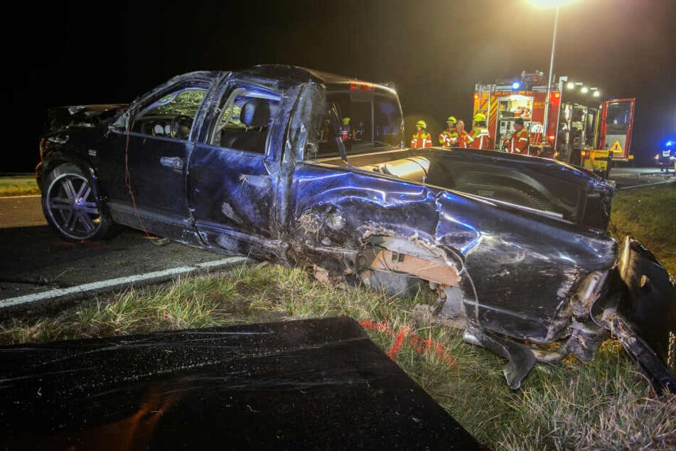 Die Feuerwehr steht hinter einem Autowrack auf der Kreisstraße, auf Höhe des Ortsteils Forchheim.