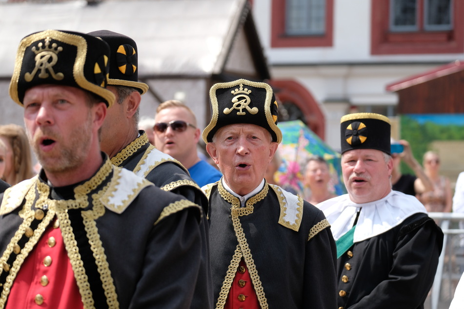 Ensemblemitglieder von Berg- und Hüttenvereinen singen beim Freiberger Bergstadtsommer vor dem Rathaus.