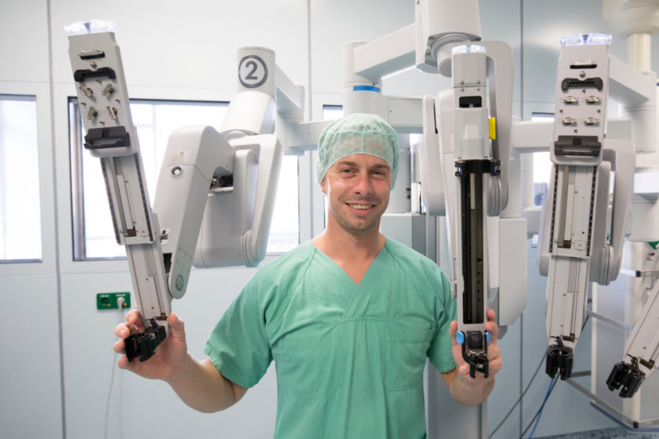 Viszeralchirurg Dr. Stefan Niebisch (36) steht vor seinem vierarmigen "Kollegen", dem OP-Roboter "DaVinci". Beiden gelang erstmals eine komplett robotergestützte Magen-Entfernung.