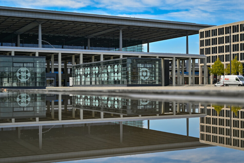 Das Hauptterminal vom Flughafen Berlin Brandenburg "Willy Brandt" (BER) spiegelt sich im Wasser eines Springbrunnens.