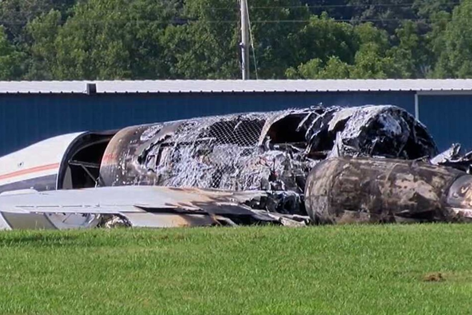 Die verbrannten Überreste des Flugzeugs liegen neben der Landebahn.