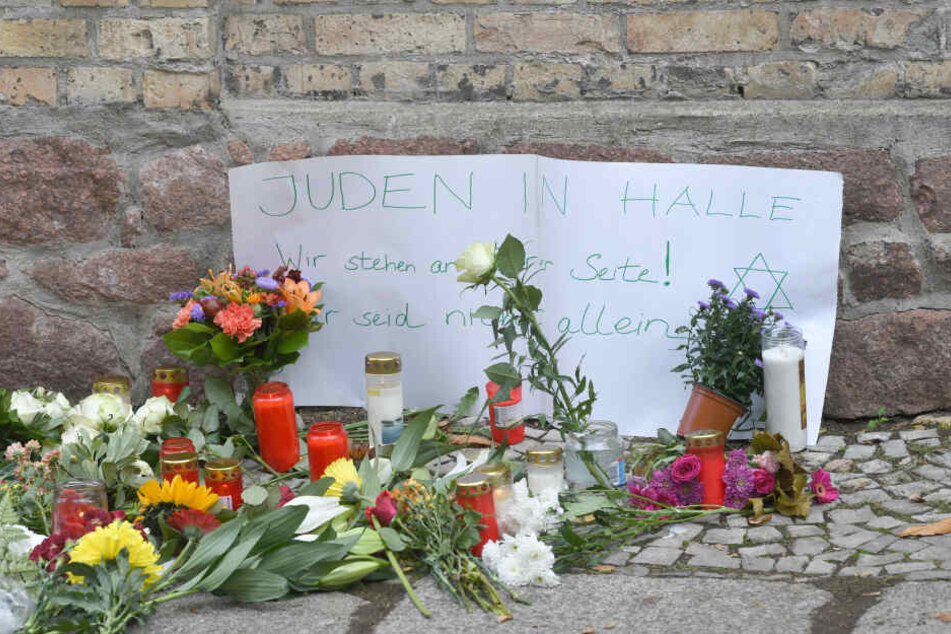 Halle: Kerzen, Blumen und ein Zettel mit der Aufschrift "Juden in Halle Wir stehen an Eurer Seite! Ihr seid nicht alleine" stehen vor der Synagoge.