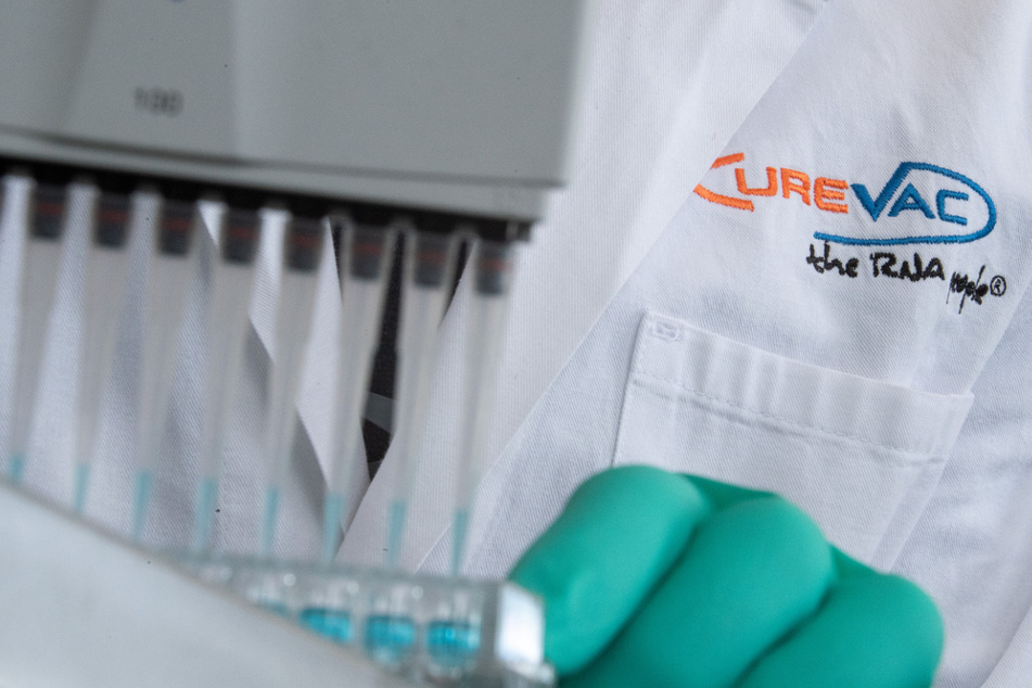 Ein Mann pipettiert in einem Labor des biopharmazeutischen Unternehmens CureVac eine blaue Flüssigkeit.