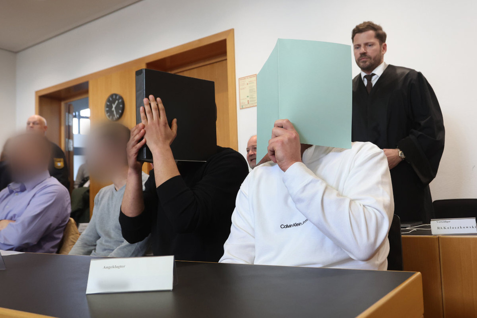 Der Hauptangeklagte (r.) und die drei Mitangeklagten müssen sich vor dem Landgericht Augsburg verantworten.