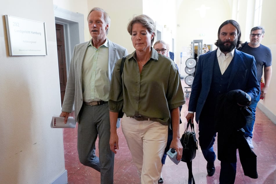 Block geht mit Bott (2.v.r.) und Wlodarek (3.v.l.) sowie Delling (l.) nach dem Ende des Prozesses wegen mutmaßlicher Kindesentführung über einen Flur im Strafjustizgebäude.