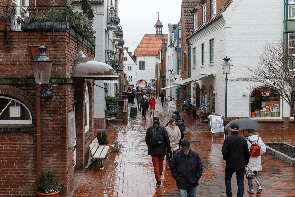 Passanten gehen gehen durch den Schlossgang in Husums Altstadt.