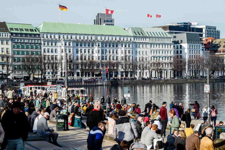 Zahlreiche Menschen genießen das sonnige Wetter am Jungfernstieg in Hamburg.