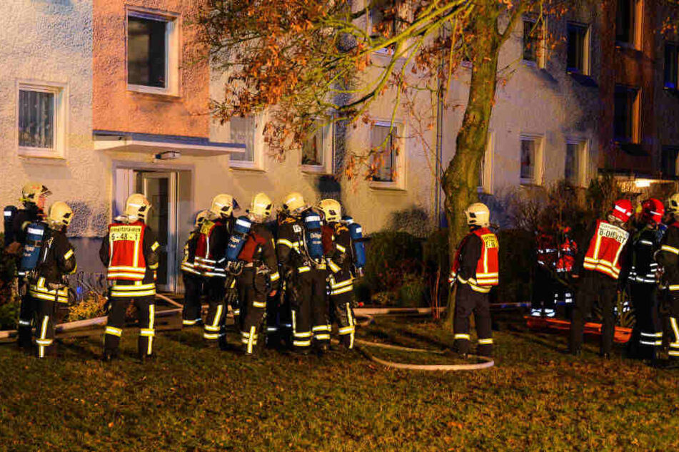 Feuerwehrleute stehen vor dem Hauseingang.