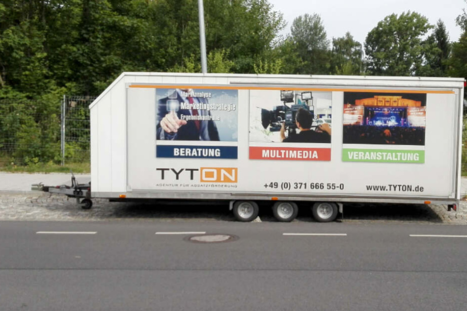 An dem Anhänger befinden sich auffällige Werbeaufdrucke.