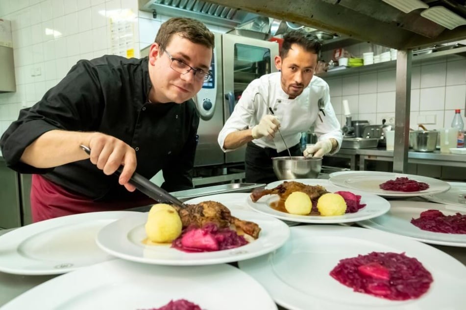 Küchenchef Sascha Gaber (31,l.) und Habib (23) richteten im "Michaelis" Gans, Rotkraut und Klöße für Bedürftige an.