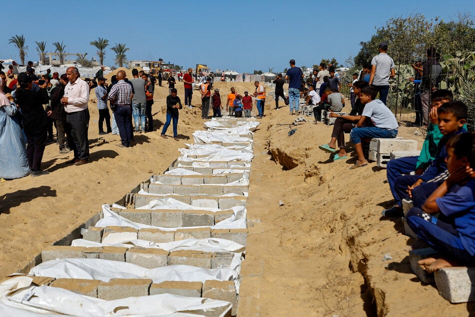 Mourners gather at a mass burial site of unidentified bodies of Palestinians handed over by Israel after a ceasefire deal, in Deir Al-Balah in the central Gaza Strip on October 22, 2025.