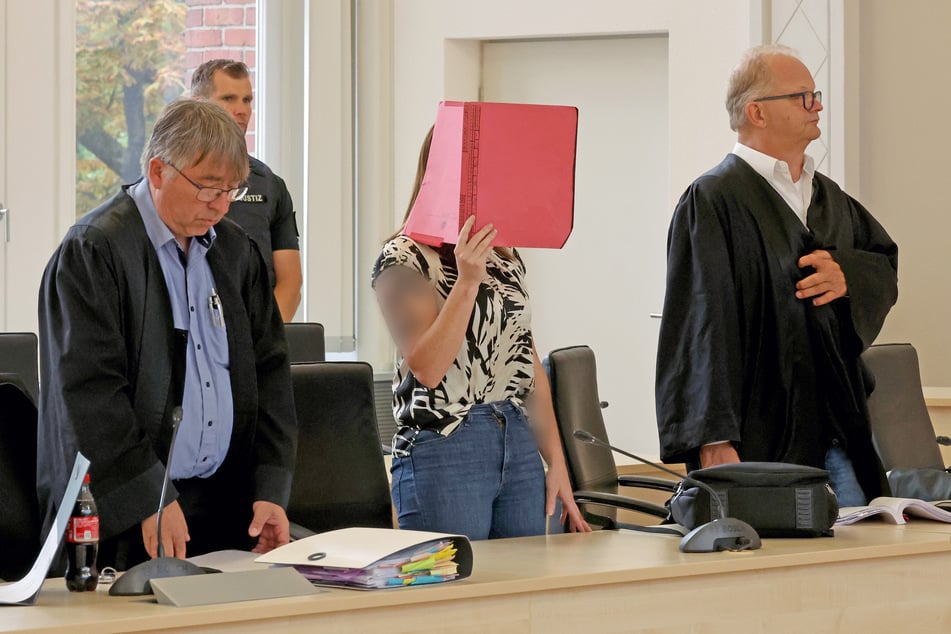 Andreas Ohm (l-r), Anwalt, die Angeklagte und Thomas Löcker, Anwalt, stehen im Saal des Landgerichts bei der Fortsetzung des Mordprozesses.
