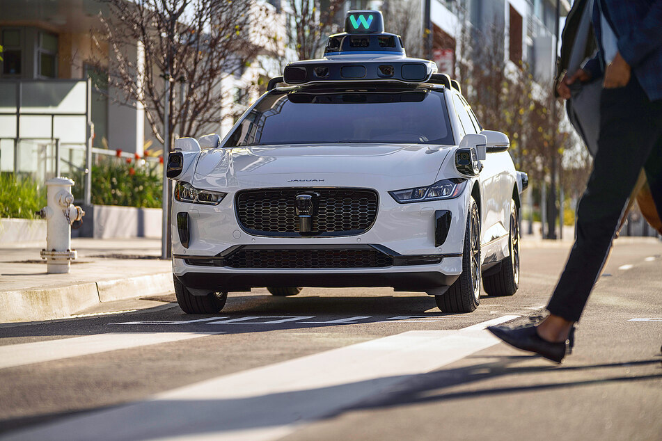 One of Waymo's self-driving cars waiting in front of a crosswalk.