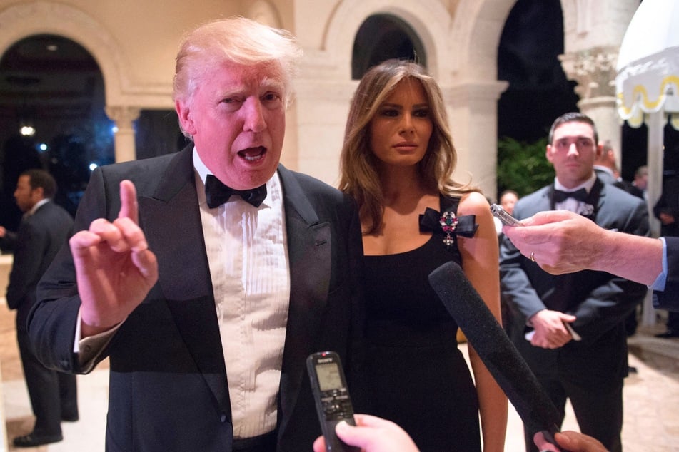 Donald Trump (l.) and his wife Melania Trump (r.) answering questions from reporters during a New Year's Eve party at their home in Palm Beach, Florida on December 31, 2016.