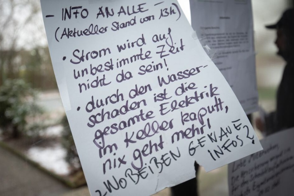 Ein Zettel im Hausflur informiert die Bewohner über den Zustand ihrer Hauses.