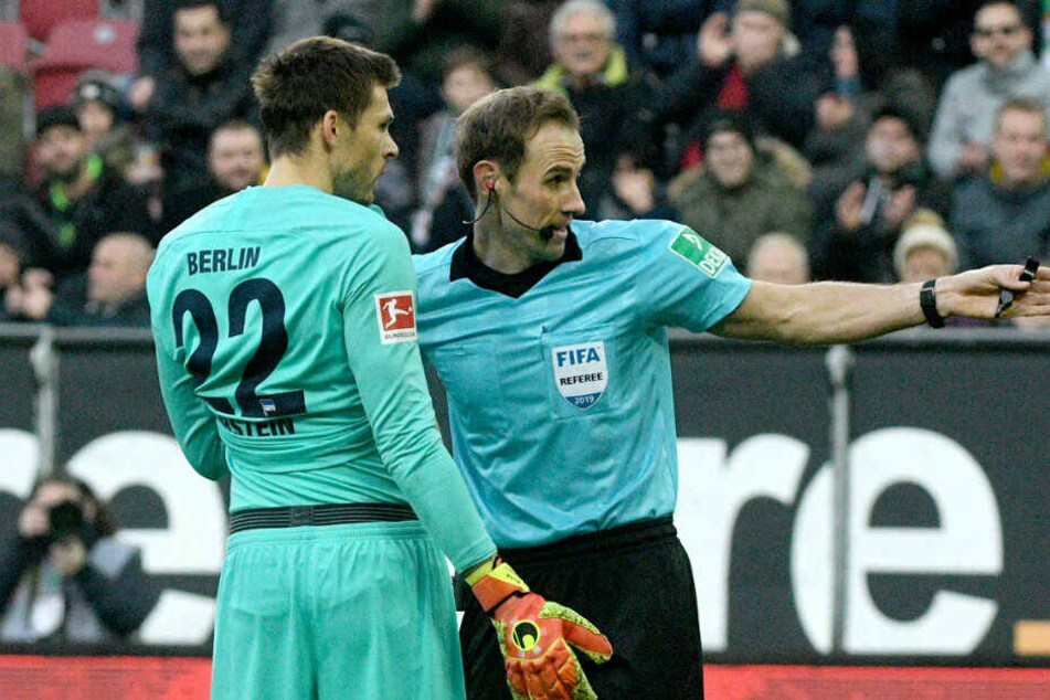 Schiedsrichter Sascha Stegemann (r.) stellt Herthas Torwart Rune Jarstein vom Platz.