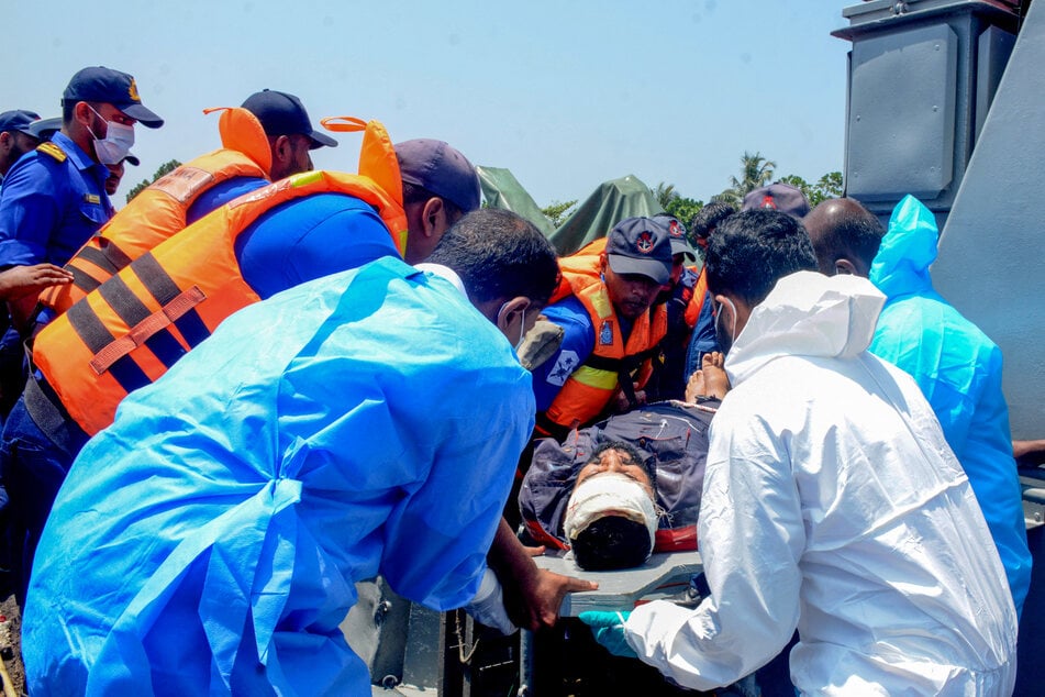 Sri Lankan navy personnel evacuating rescued Iranian sailors from the IRIS Dena frigate after a US submarine attack off Sri Lanka's southern coast in Galle.