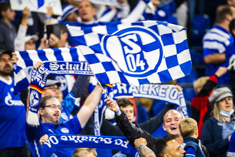 Schalke 04 Fans feiern, schwenken Fahnen und wedeln mit den Schals - das Stadion tobt.