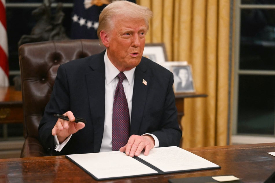 US President Donald Trump signs an executive order on the US withdrawal from WHO (World Health Organization) in the Oval Office of the White House in Washington, DC, on January 20, 2025.