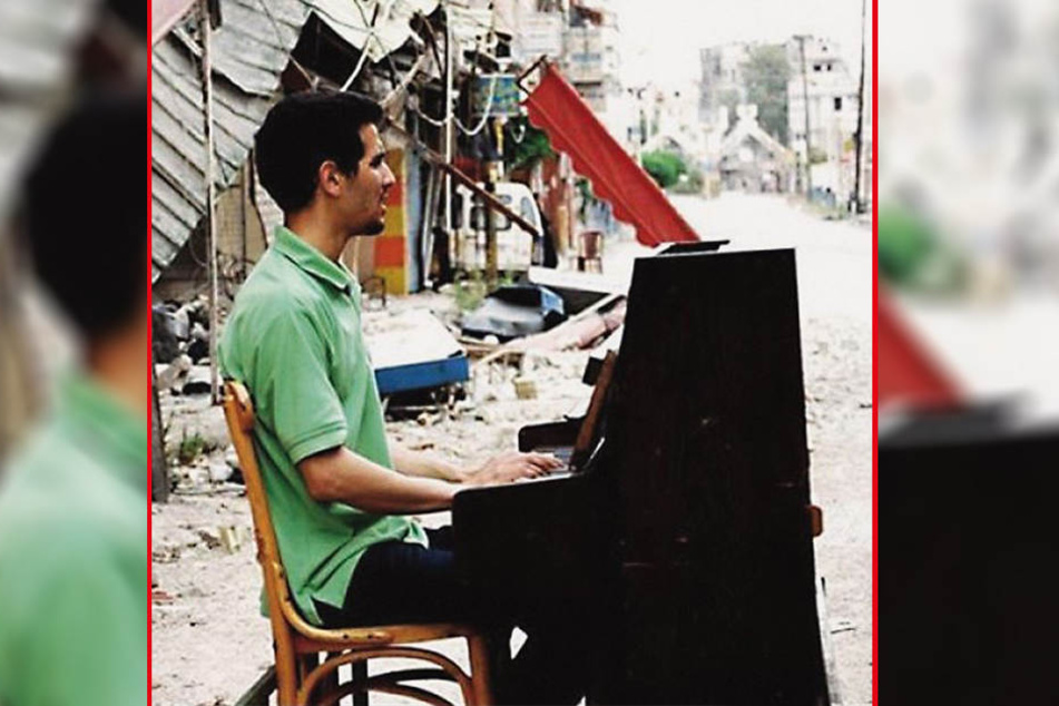 Dieses Bild ging um die Welt: Mitten im syrischen Bürgekrieg sitzt Aeham Ahmad zwischen Ruinen auf der Straße und spielt Klavier. Eingefangen wurde das Bild von Niraz Saied (†27).