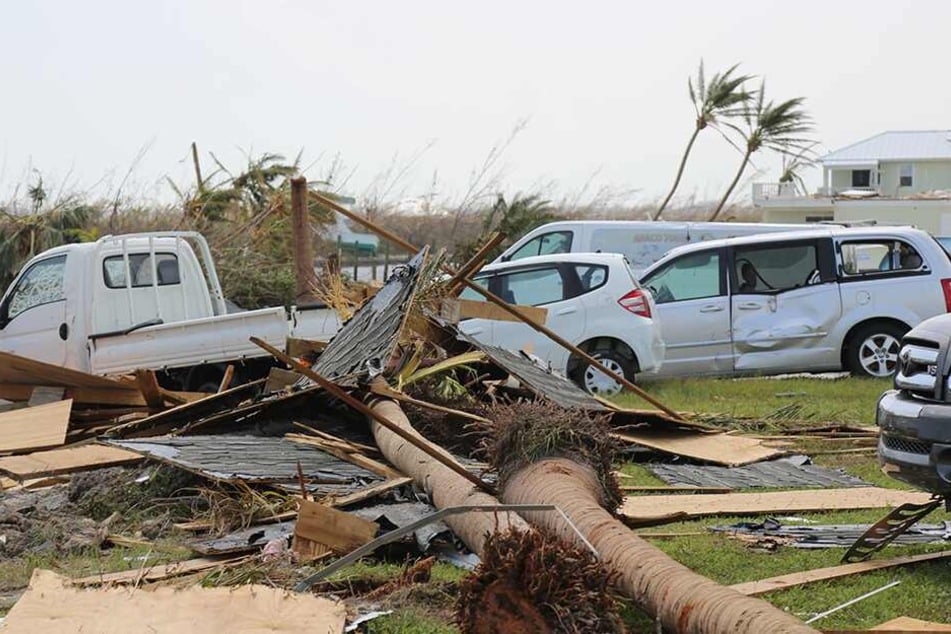 Zerstörungen durch den Hurrikan Dorian im Marsh Harbour auf Great Abaco Island. Autos und Lastwagen sind nach dem Sturm unter Palmen, Schutt und Trümmern begraben.