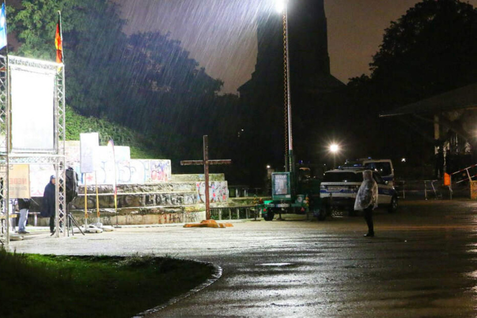 Bei strömenden Regen steht ein Pegida-Anhänger bei der Kundgebung im Görlitzer Park.