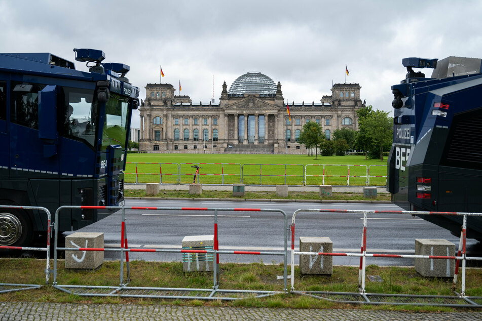 Vor dem Reichstagsgebäude stehen Wasserwerfer.