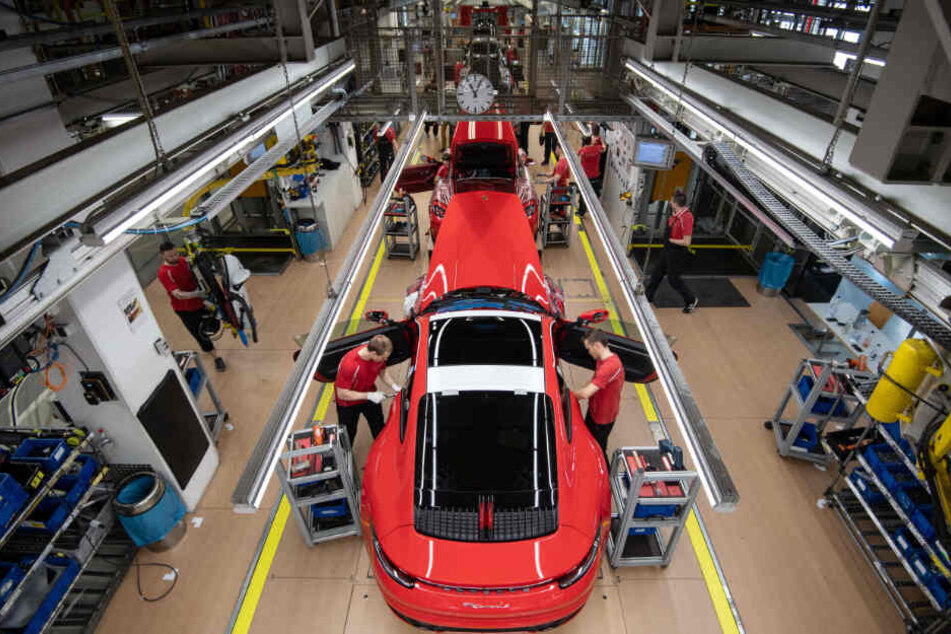 Mitarbeiter montieren im Hauptwerk einen Porsche.
