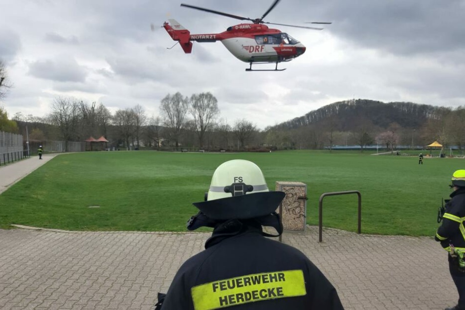 Feuerwehrleute beobachten den Start des Hubschraubers.