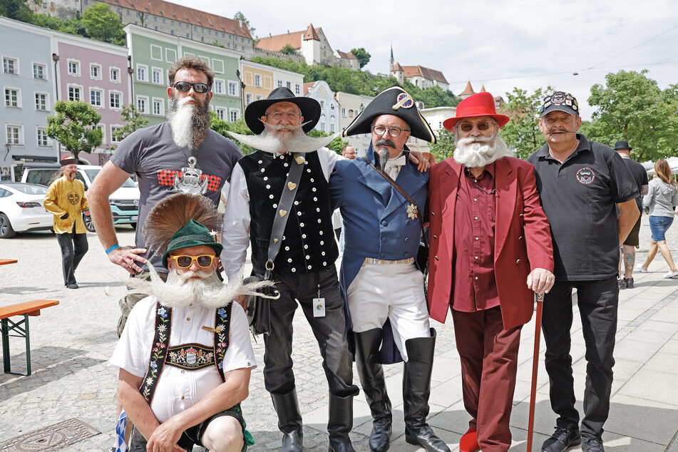 Teilnehmer der Bart- und Schnurrbart-Weltmeisterschaften posieren vor der historischen Kulisse von Burghausen.