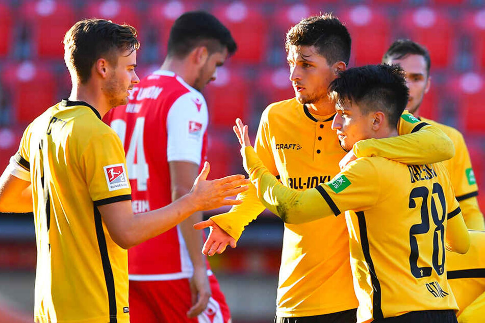 Dynamos Spieler Lucas Röser (l.) und Jannis Nikolaou (Zweiter von r.) beglückwünschen Baris Atik (r.) zu dessen 1:1-Ausgleichstreffer.